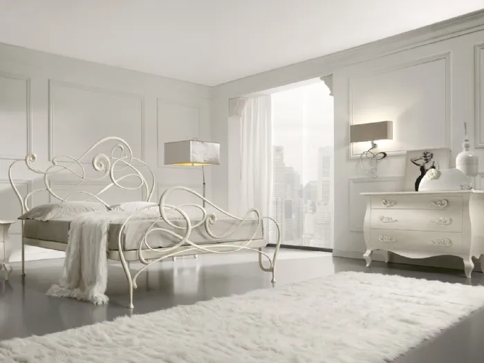 Camera da letto bianca con lampade design e letto in ferro battuto