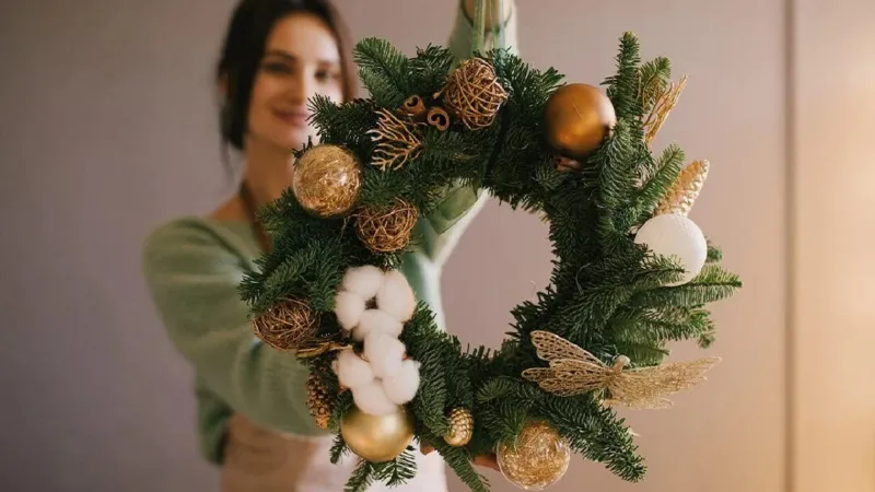 Una ghirlanda fai da te con materiali riciclati per la porta di Natale