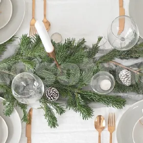 Tavola di Natale bianca e verde con posate dorate