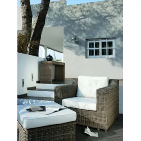 terrazza outdoor con mobili in bambù e cuscini bianchi, quaderni su pouf e tre gradini
