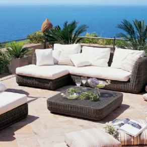 divani e poltrona da esterno in fibra intrecciata marrone con cuscini panna su terrazza con vista mare, tavolino corredato, cuscini e palme