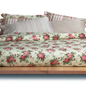 letto matrimoniale con copripiumino panna con rose e cusicni a righe abbinati