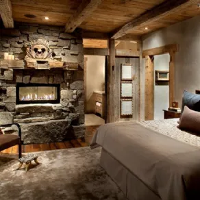 camera da letto rustica con parete in pietra