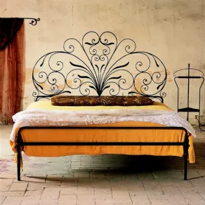 letto in ferro battuto in camera rustica