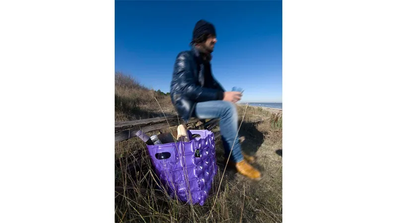 ragazza su prato con borsa viola