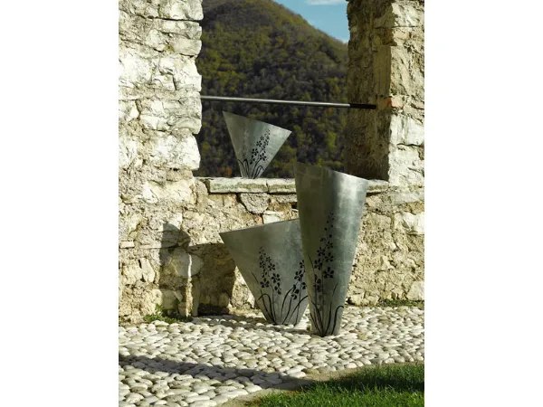 tre vasi in legno color argento con decorazioni floreali viola su muro a secco