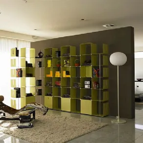 libreria in metallo verde mela, lampada da terra con paralume ovoidale bianco, tappeto in peo beige, chaise-longue