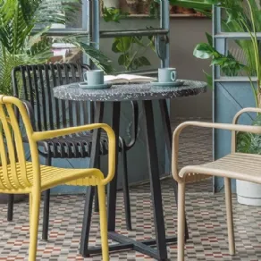 Tella by Kave Home ha il piano in terrazzo nero e basamento di acciaio zincato