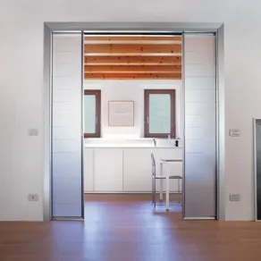 Controtelaio con illuminazione, interruttori e prese sulla parete. Soluzione per due ante speculari a scomparsa.
