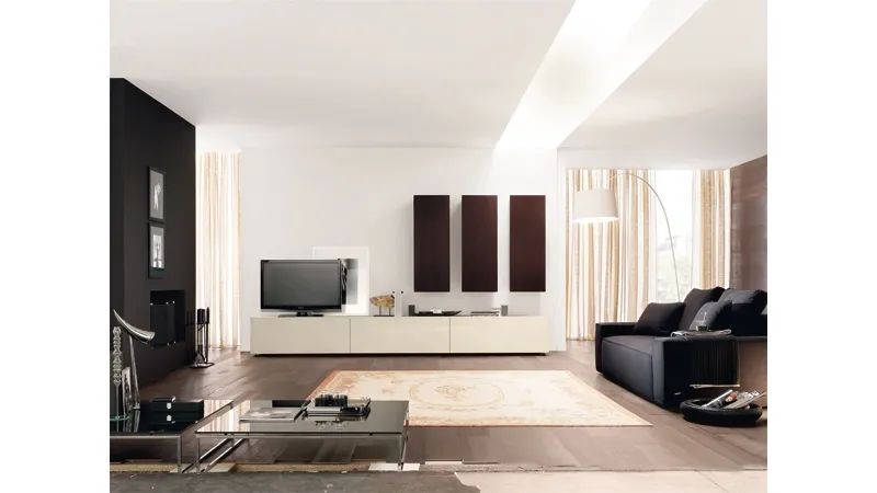 salotto con pavimento i parquet scuro, mobile tv panna, tre armadi rettangolari verticali neri, divano nero sulla destra