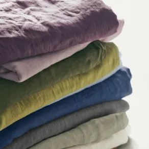 set di lenzuola piegate in lino nei colori melanzana, rosa, verde pino, verde chiaro, azzurro, blu e naturali