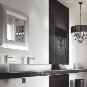 arredo bagno con piastrelle bianche e nere, lampadario con paralume circolare nero e gocce, specchio quadrato con cornice argentata