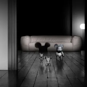 tre vynil toys a forma di topo grigi e argentati, pavimento in legno grezzo e divano panna sullo sfondo