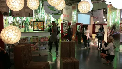 stand espositivo con lampade sferiche e sedute in cartone, visitatori