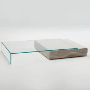 tavolino con piano in cristallo trasparente appoggiato su parallelepipedo in pietra