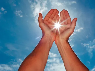 mani che tengono un raggio di sole