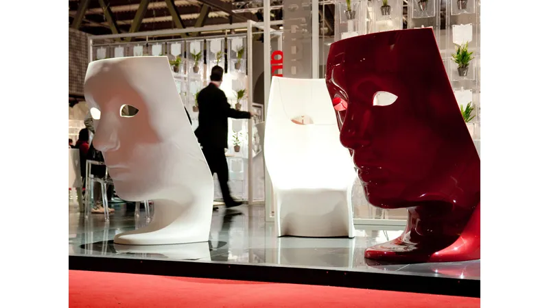 tre sedute a forma di maschera bianche e rosse in spazio espositivo