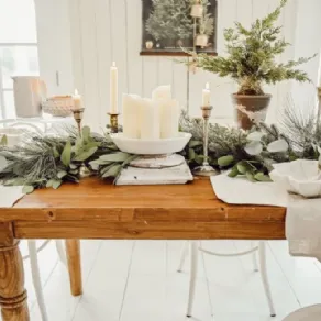 Il centrotavola bianco, con candele e aghi di Pino resta un evergreen natalizio