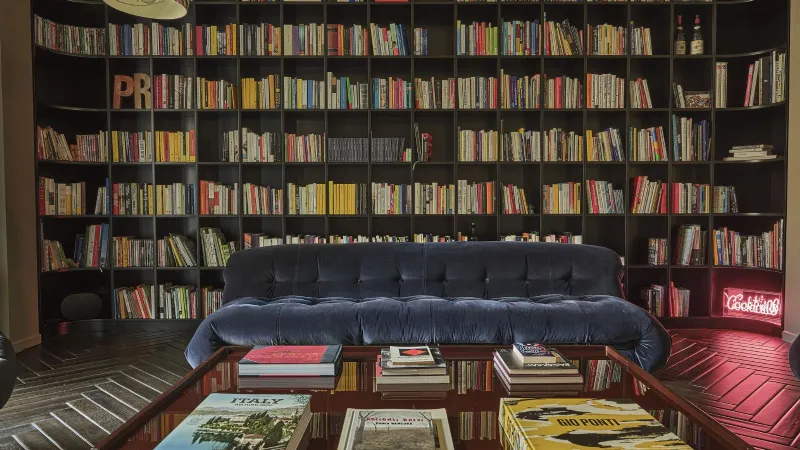 La libreria su misura e i divani ribadiscono la matrice anni Settanta del progetto  