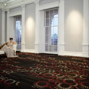 Donna distesa su shaslong in stanza luminosa con pavimento tessile