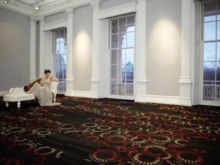 Donna distesa su shaslong in stanza luminosa con pavimento tessile