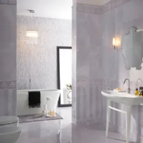 bagno nei toni del lilla con sanitari in porcellana bianca, specchio rettangolare appoggiato a parete, e specchio rococò 