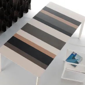 veduta dall'alto di tavolo con piano a righe in toni neutri, sedia design geometrica bianca