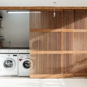 Soluzione progettuale per ricavare spazio lavatrice in balcone con parete arredo in legno