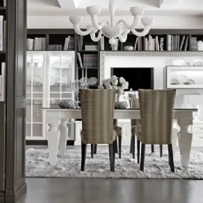 panoramica living con tavolo da pranzo bianco su tappeto di pelo grigio, sedie foderate e lampadario a sei bracci bianco