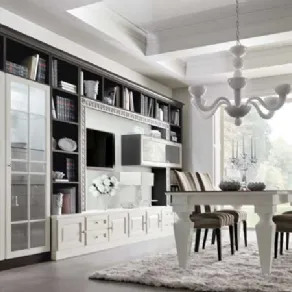 panoramica zona living: vetrina, libreria con spazio tv e cassettiera, tavolo bianco, sedie foderate e lampadario bianco