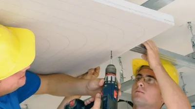 due operai con caschi gialli e trapano