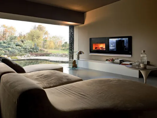 zona living con divani in suede marrone e camino da parete con schermo lcd
