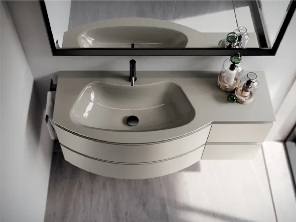 Base sinuosamente stondata e lavabo integrato curvo in cristallo laccato lucido in questa elegante soluzione firmata Ideagroup (collezione Form)