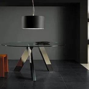 zona living con tavolino con piano in vetro trasparente circolare, seduta arancione e lampada con paralume circolare nero