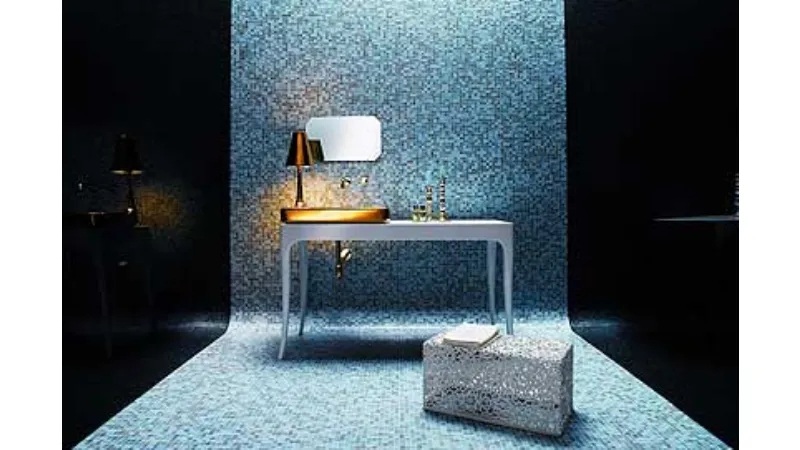 fascia di parete e pavimento a mosaico nelle tinte del blu con tavolino bianco, abat jour con lavabo dorati e puf in ferro battuto bianco