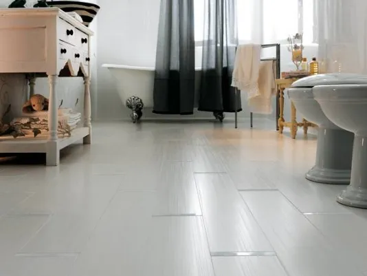 pavimento bagno in grès color grigio chiaro, vasca con piedi dorati e tenda nera