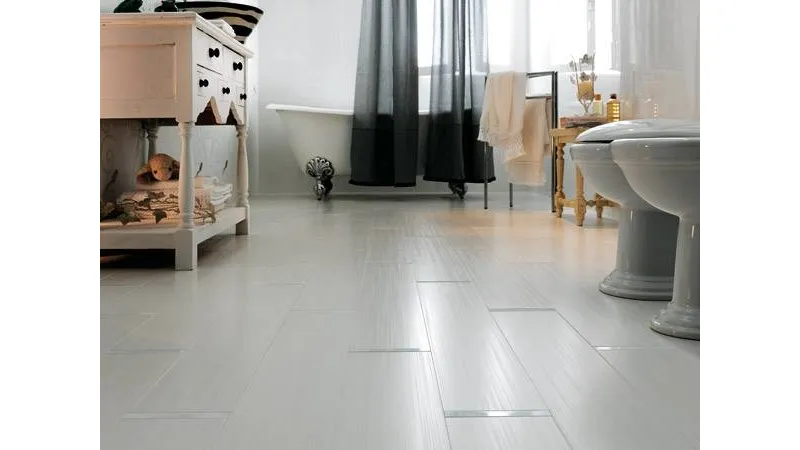 pavimento bagno in grès color grigio chiaro, vasca con piedi dorati e tenda nera