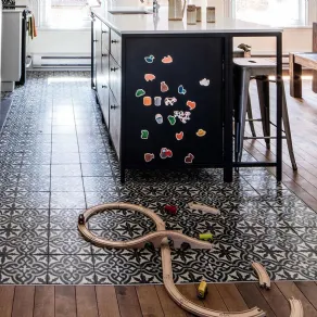 Parquet e cementine decorate per realizzate un tappeto multicolor all'interno di una cucina openspace