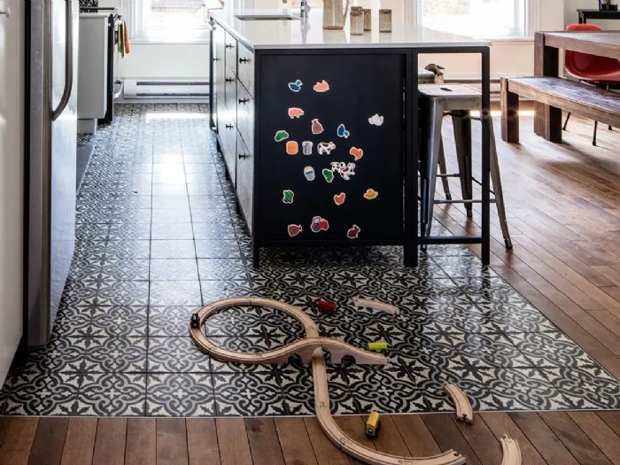 Parquet e cementine decorate per realizzate un tappeto multicolor all'interno di una cucina openspace