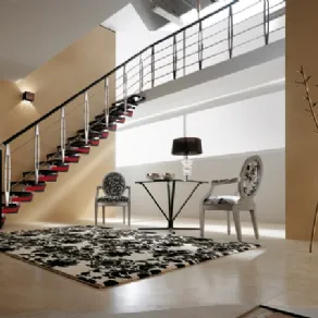 veduta angolare di zona living con scala con gradini neri e dettagli rossi, tappeto bianco con disegni neri, due sedie luigi XVI con stesso rivestimento