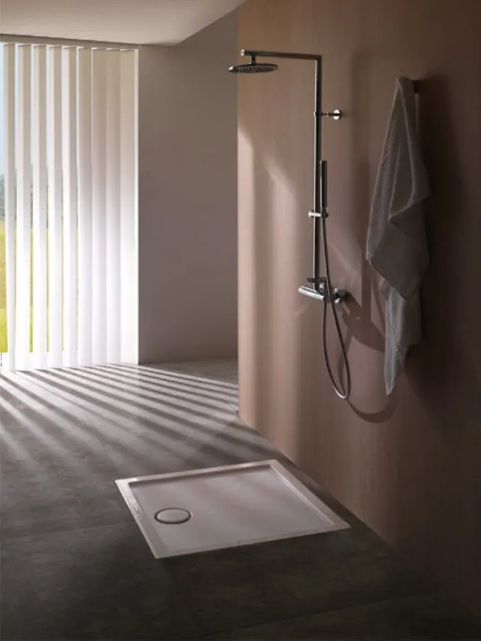 piatto doccia quadrato a terra opaco e microfono doccia a parete senza pareti divisorie, asciugamano bianco appeso alla parete 