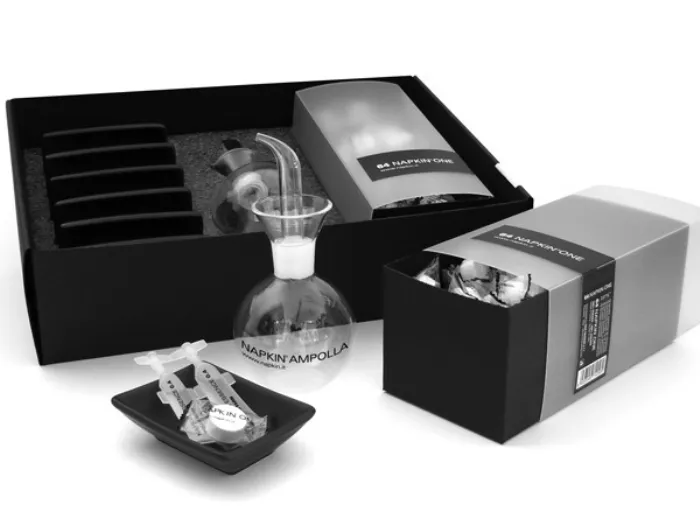 due scatole nere con coperchio trasparente con salviette bianche compresse, ampolla in vetro trasparente