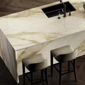 Infinity propone il pregiato gres effetto marmo Calacatta Hermitage con base avorio e venature dorate, grigie e arancioni