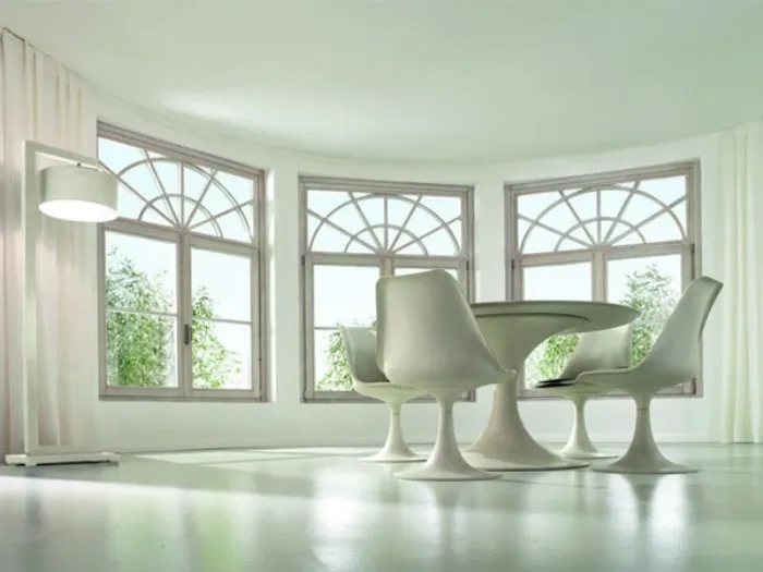 zona living con tavolo e sedute design bianche, parete finestrata, lampada da terra bianca