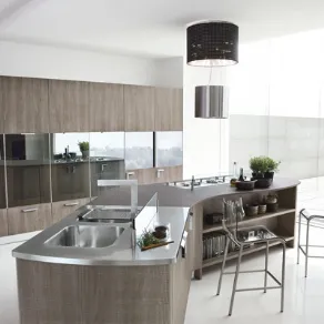 cucina in legno e acciaio con dettagli a specchio su armadiatura, isola centrale con lavabo, piano cottura, piano di lavoro e tavolo snack con due sgabelli
