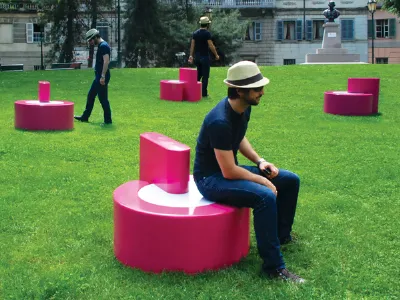 ragazzo su seduta design fucsia, lo stesso ragazzo in piedi con seduta ripetuto due volte sullo sfondo