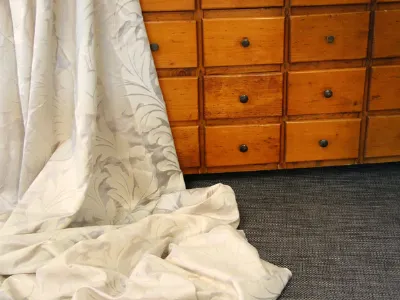 Cassettiera in legno con tenda adagiata sopra