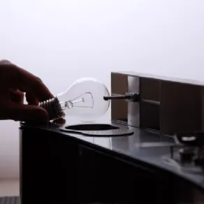 dettaglio plastico di cucina con mano che sorregge una lampadina
