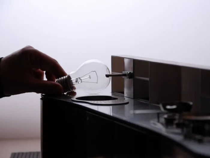 dettaglio plastico di cucina con mano che sorregge una lampadina