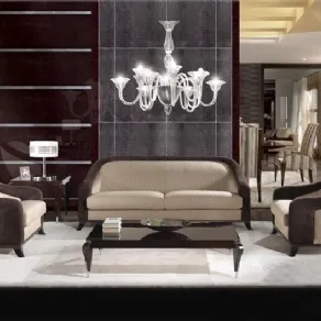 salotto con divani color panna con bordi in velluto marrone, tavolino nero e lampadario in vetro trasparente